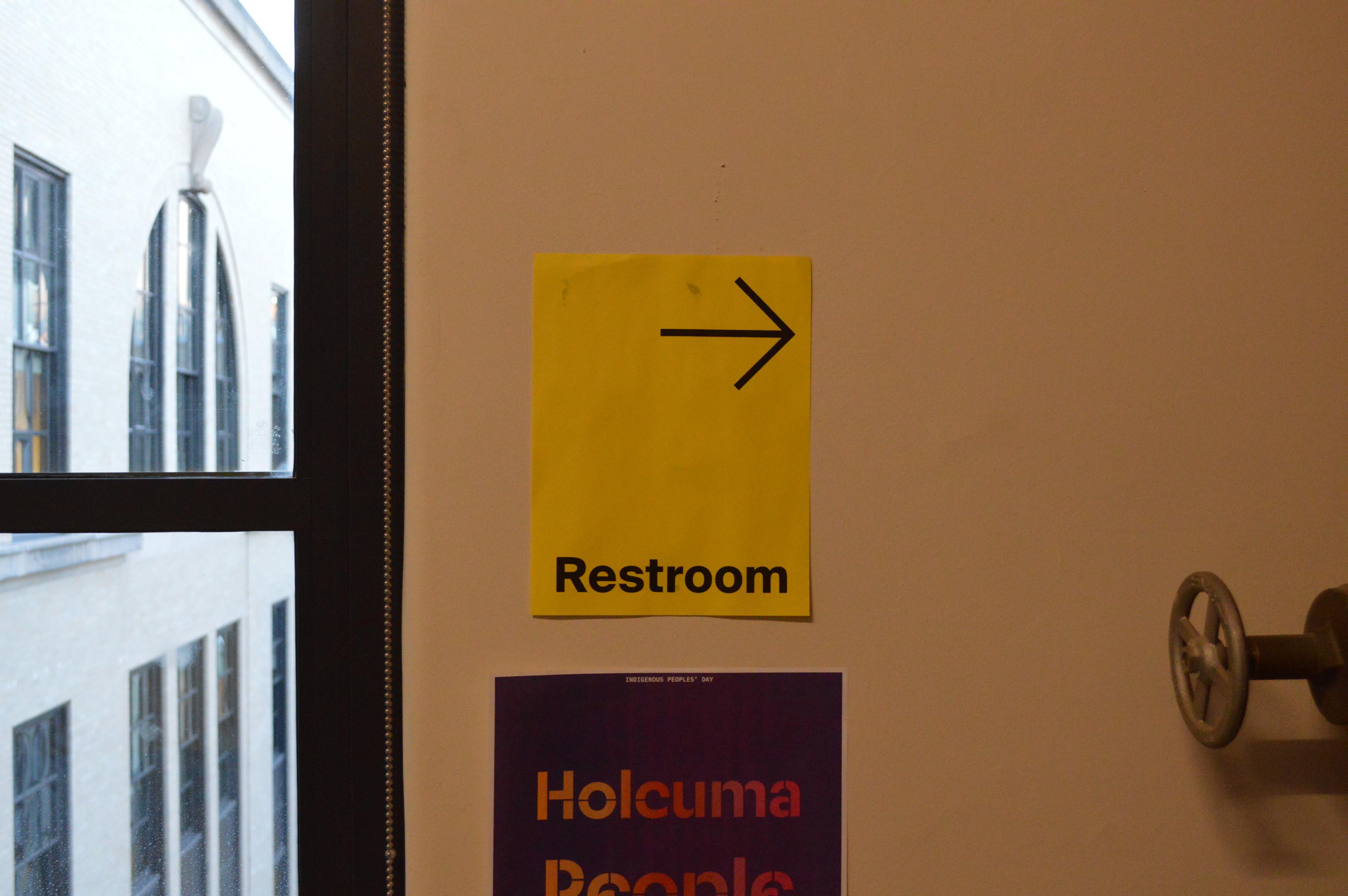 Photo of bright yellow bathroom sign