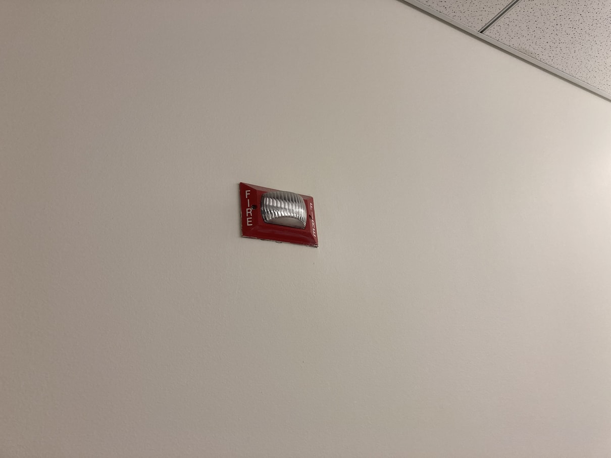 A very small fire alarm on wall.